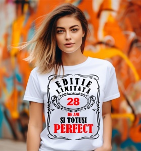 Femeie care poartă un tricou alb personalizat cu mesajul: ''28 de ani si totusi perfect''.