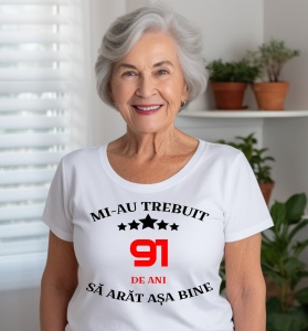 Femeie care poartă un tricou alb personalizat cu mesajul: ''Mi-au trebuit 91 de ani sa arat asa bine''