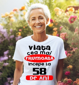 Femeie care poartă un tricou alb personalizat cu mesajul: ''Viata cea mai frumoasa incepe la 58 de ani''.