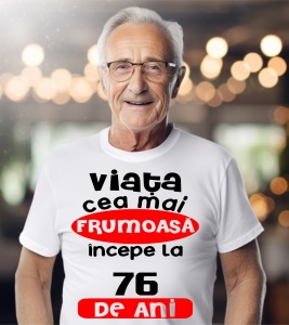 Un bărbat purtând un tricou alb cu textul ''Viața cea mai frumoasă începe la 76 de ani''.