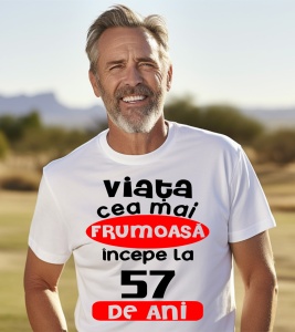 Un bărbat purtând un tricou alb cu textul ''Viața cea mai frumoasă începe la 57 de ani''.