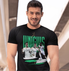 Un bărbat zâmbitor poartă un tricou negru cu un design grafic dedicat jucătorului de fotbal Vinícius, incluzând imagini ale acestuia în acțiune și numele său scris cu litere verzi.
