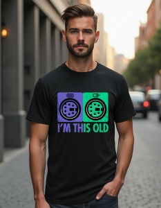 Un bărbat purtând un tricou negru cu un design ce afișează două conectori PS/2 pentru mouse și tastatură, alături de textul 'I'm this old', sugerând o temă nostalgică legată de tehnologia veche.