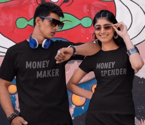Un bărbat și o femeie purtând tricouri negre, bărbatul cu textul 'Money Maker' și femeia cu textul 'Money Spender', pozând cu atitudine în fața unui perete colorat, cu detalii artistice.