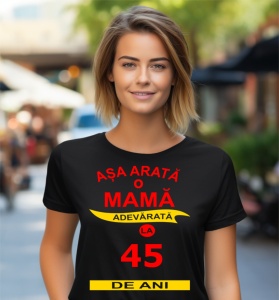 Femeie zâmbitoare purtând un tricou cu mesajul: ''Așa arată o mamă adevărată la 45 de ani''