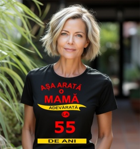 Femeie zâmbitoare purtând un tricou cu mesajul: ''Așa arată o mamă adevărată la 55 de ani''