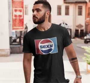 Un bărbat purtând un tricou negru cu un design inspirat de logo-ul Pepsi, dar cu textul 'Sexy' în centru, pozând într-un mediu urban.
