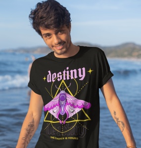Un tânăr zâmbitor poartă un tricou negru cu un design mistic ce include cuvântul 'destiny' scris cu litere roz și o ilustrație detaliată a unui fluture colorat în nuanțe de mov și roz, în fața unei forme geometrice. Textul de jos spune 'The choice is your