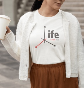 Femeie purtând un tricou alb cu un design grafic care formează cuvântul 'life' și mesajul 'is short. live it!', alături de săgeți stilizate, îmbrăcată într-un cardigan alb și ținând o cană de cafea.