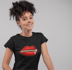 Fată zâmbitoare purtând un tricou negru cu un design grafic ce afișează buze roșii cu un fermoar închis, pe un fundal gri simplu.
