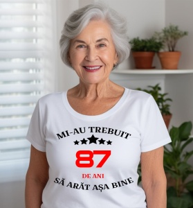 Femeie care poartă un tricou alb personalizat cu mesajul: ''Mi-au trebuit 87 de ani sa arat asa bine''