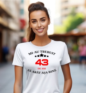 Femeie care poartă un tricou alb personalizat cu mesajul: ''Mi-au trebuit 43 de ani sa arat asa bine''