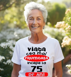 Femeie care poartă un tricou alb personalizat cu mesajul: ''Viata cea mai frumoasa incepe la 75 de ani''.