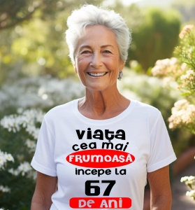 Femeie care poartă un tricou alb personalizat cu mesajul: ''Viata cea mai frumoasa incepe la 67 de ani''.