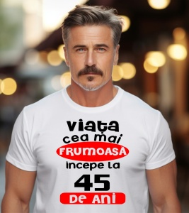 Un bărbat purtând un tricou alb cu textul ''Viața cea mai frumoasă începe la 45 de ani''.