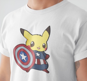 Prim-plan al unui tricou alb cu un design care înfățișează personajul Pikachu îmbrăcat ca Captain America, ținând un scut în culorile roșu, alb și albastru.
