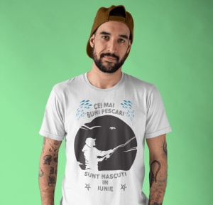 Imagine cu un bărbat purtând un tricou alb pe care este imprimat un design cu mesajul 'Cei mai buni pescari sunt născuți în iunie', cu o siluetă de pescar și ilustrații de pești.