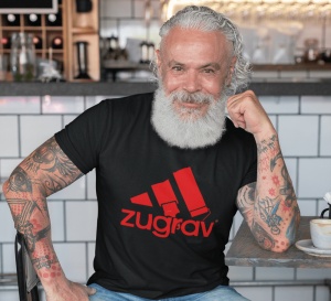 Un bărbat cu barbă albă și tatuaje pe brațe poartă un tricou negru cu un design amuzant inspirat de un logo faimos, înfățișând trei dungi stilizate ca pensule de zugrăvit și textul 'zugrav' scris dedesubt. Bărbatul stă relaxat într-o cafenea.