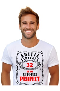 Un bărbat purtând un tricou alb cu mesajul: „Ediție limitată, 32 de ani și totuși perfect”. Bărbatul afișează o atitudine veselă și pozitivă.