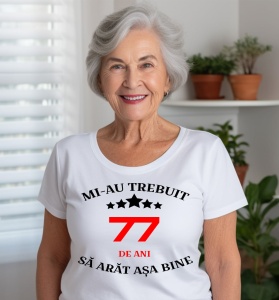 Femeie care poartă un tricou alb personalizat cu mesajul: ''Mi-au trebuit 77 de ani sa arat asa bine''