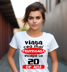 Femeie care poartă un tricou alb personalizat cu mesajul: ''Viata cea mai frumoasa incepe la 20 de ani''.