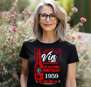 Femeie zâmbitoare purtând un tricou negru cu un mesaj în română despre vin, în care se menționează că este ca un vin bun care devine mai nobil cu vârsta, îmbuteliat în 1959, cel mai bun an.
