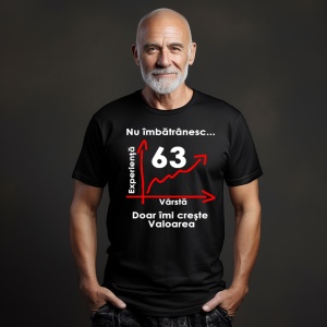 Un bărbat cu barbă albă și capul ras, purtând un tricou negru cu mesajul: „Nu îmbătrânesc... Doar îmi crește valoarea” și un grafic care indică vârsta de 63 de ani pe axa vârstei și experienței. Bărbatul se află într-un cadru simplu, cu un fundal întuneca