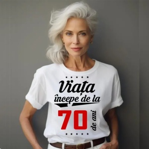 Femeie care poartă un tricou alb personalizat cu mesajul: ''Viața începe de la 70 de ani''