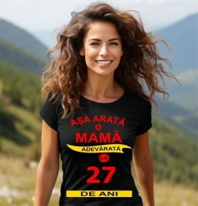 Femeie zâmbitoare purtând un tricou cu mesajul: ''Așa arată o mamă adevărată la 27 de ani''