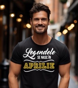 Un bărbat zâmbitor purtând un tricou negru cu mesajul: „Legendele se nasc în Aprilie”.