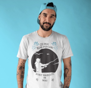 Imagine cu un bărbat purtând un tricou alb pe care este imprimat un design cu mesajul 'Cei mai buni pescari sunt născuți în mai', cu o siluetă de pescar și ilustrații de pești.