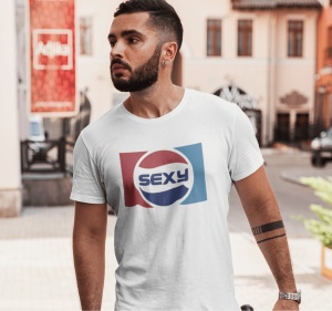 Un bărbat purtând un tricou alb cu un design inspirat de logo-ul Pepsi, dar cu textul 'Sexy' în centru, pozând într-un mediu urban.