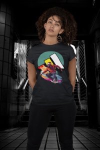 Femeie cu păr creț purtând un tricou negru cu un design grafic colorat ce prezintă un skater, pozând într-un pasaj subteran întunecat și modern.