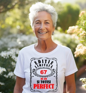 Femeie care poartă un tricou alb personalizat cu mesajul: ''67 de ani si totusi perfect''.