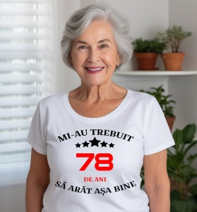 Femeie care poartă un tricou alb personalizat cu mesajul: ''Mi-au trebuit 78 de ani sa arat asa bine''