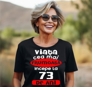 Femeie care poartă un tricou negru personalizat cu mesajul: ''Viata cea mai frumoasa incepe la 73 de ani''.