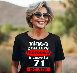 Femeie care poartă un tricou negru personalizat cu mesajul: ''Viata cea mai frumoasa incepe la 71 de ani''.