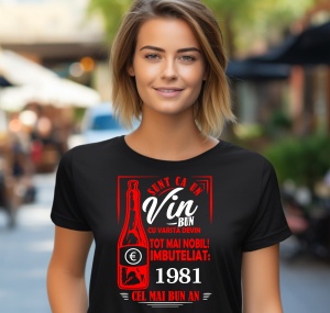 Femeie zâmbitoare purtând un tricou negru cu un mesaj în română despre vin, în care se menționează că este ca un vin bun care devine mai nobil cu vârsta, îmbuteliat în 1981, cel mai bun an.