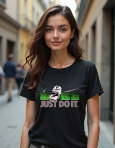 Tricou negru purtat de o femeie, având un design care include logo-ul 'Nike' stilizat în culori verzi și gri, cu sloganul 'Just Do It' dedesubt. Logo-ul este acompaniat de un personaj animat așezat pe vârful unui swoosh, în partea superioară.