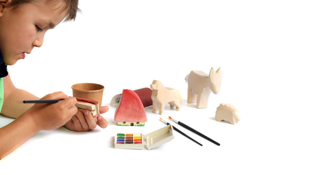 Kid painting wooden toys