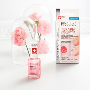 Imaginea prezintă produsul Tratament Intensiv Unghii Distruse Reconstrucție și Reparare de la Eveline Cosmetics pe un fundal alb. Un model cu unghii impecabile demonstrează beneficiile produsului.