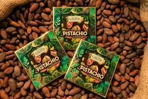 Mini delicii GALFFIS – ciocolată cu lapte și cremă de fistic, 20 g – prezentare pe pat de boabe de cacao
