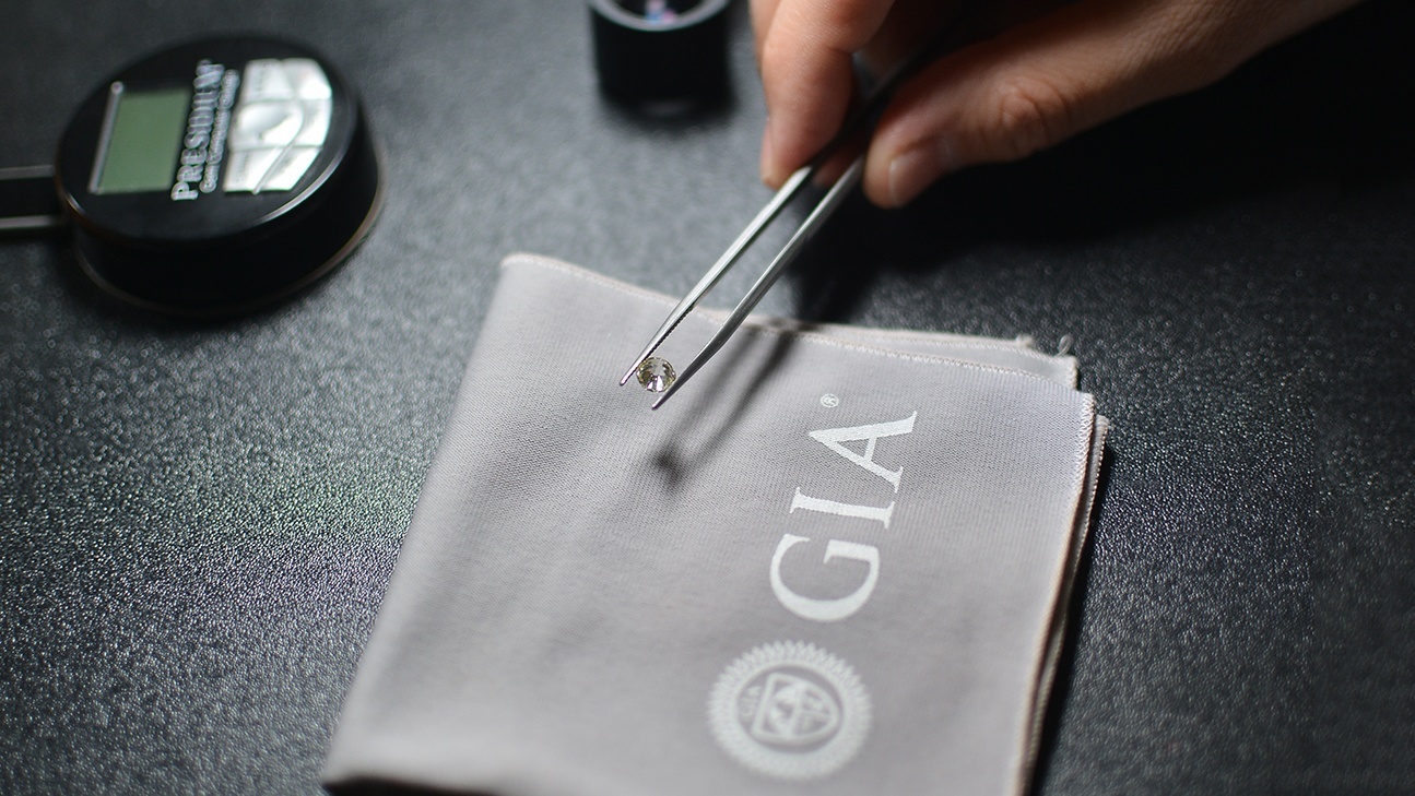 Gemolog licentiat GIA inspectand un diamant pentru evaluare diamante și certificare gemologica in Bucuresti