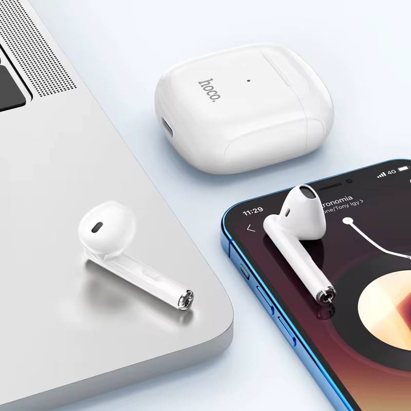 Imagine de aproape cu căștile wireless de culoare albă în cutia de încărcare.