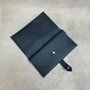 Portofel Saffi Black din piele neagră mat, cu 11 buzunare și închidere cu capsă argintie.