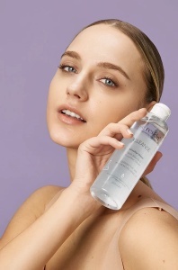 Tânără cu ten curat și luminos ține flaconul de apă micelară Cleanse Sereskin, 250 ml